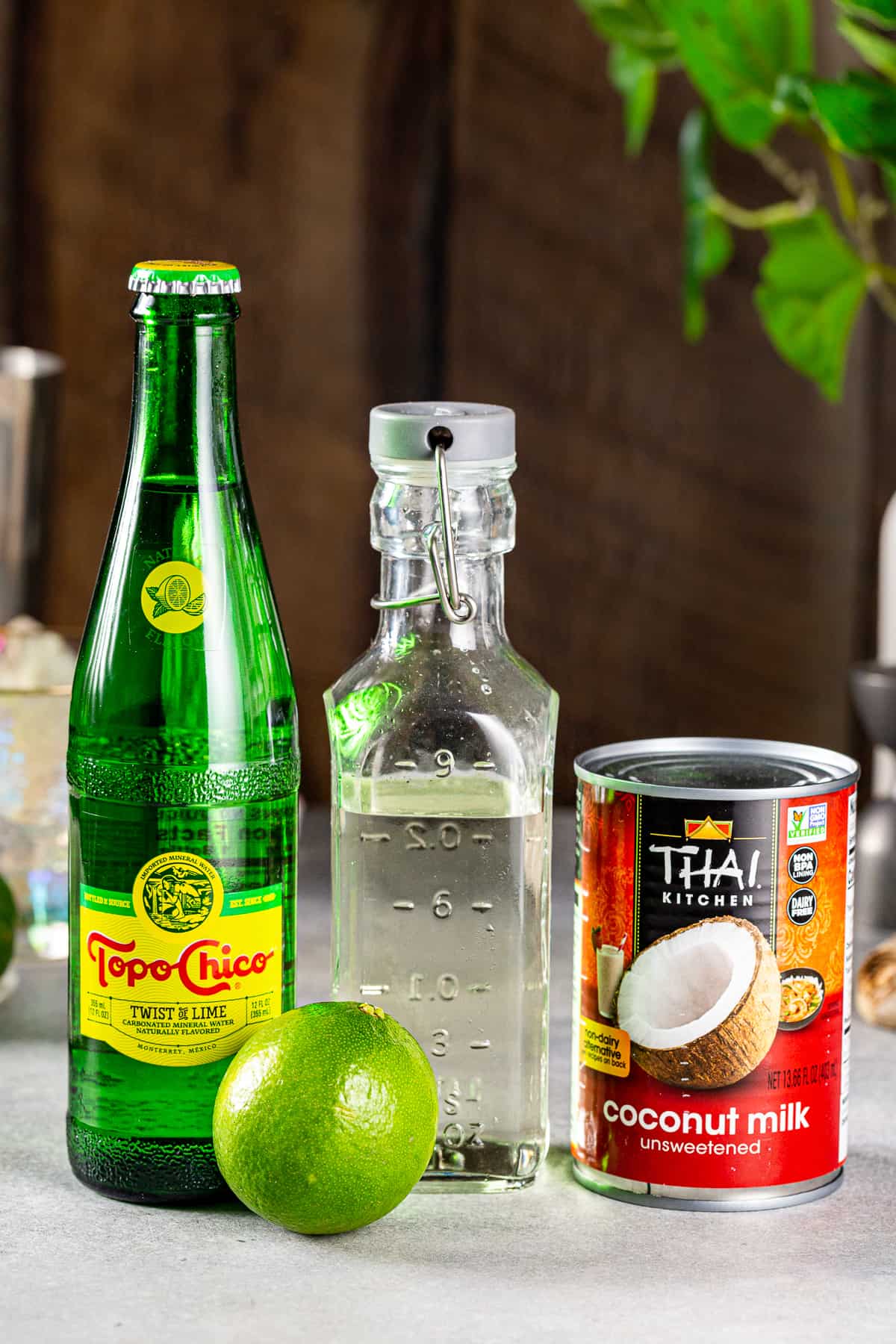 Ingredients to make a lime mocktail with coconut together on a countertop.