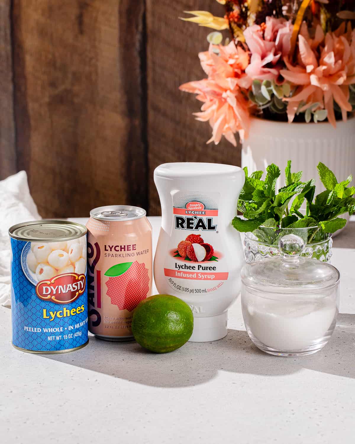 Ingredients to make a Lychee Mocktail together on a countertop.