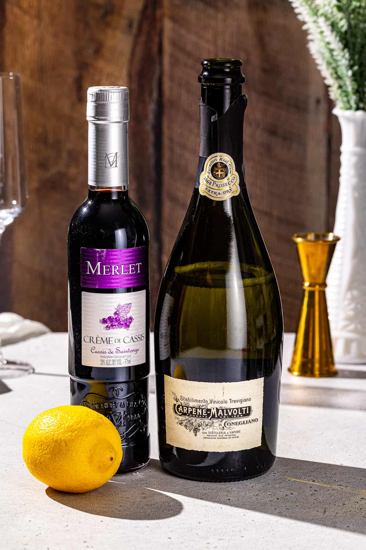 Ingredients to make a Kir Royale cocktail together on a countertop.