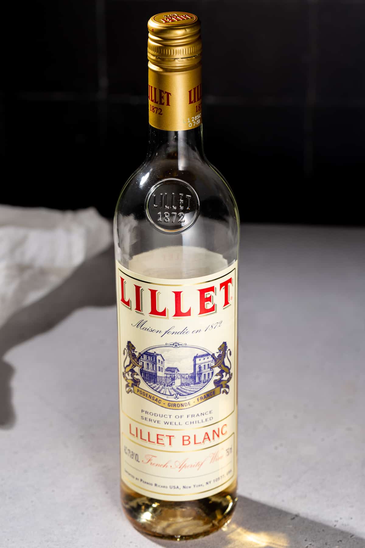 A bottle of Lillet Blanc aperitif on a countertop.