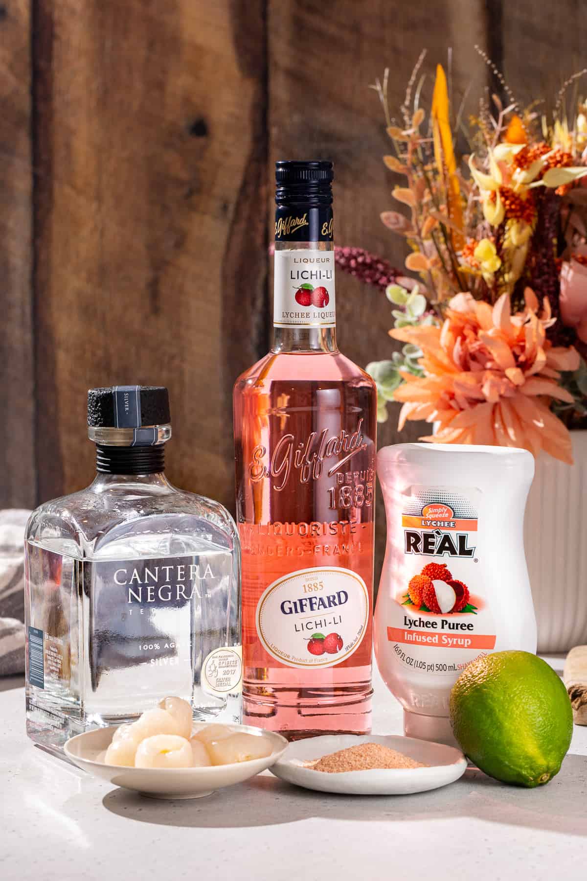 Ingredients to make a Lychee Margarita together on a countertop.