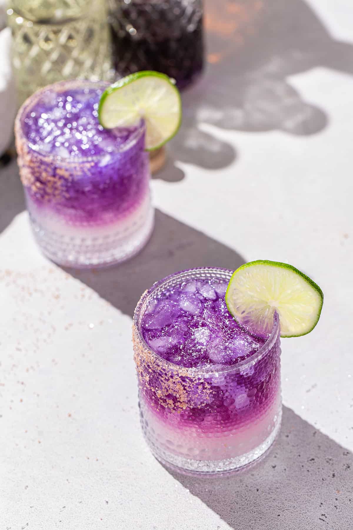 Overhead view of two Galaxy Margaritas with lime slice garnishes.