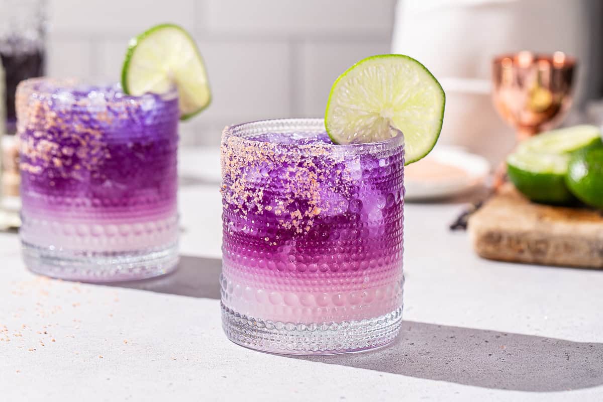 Side view of two galaxy margaritas on a countertop.