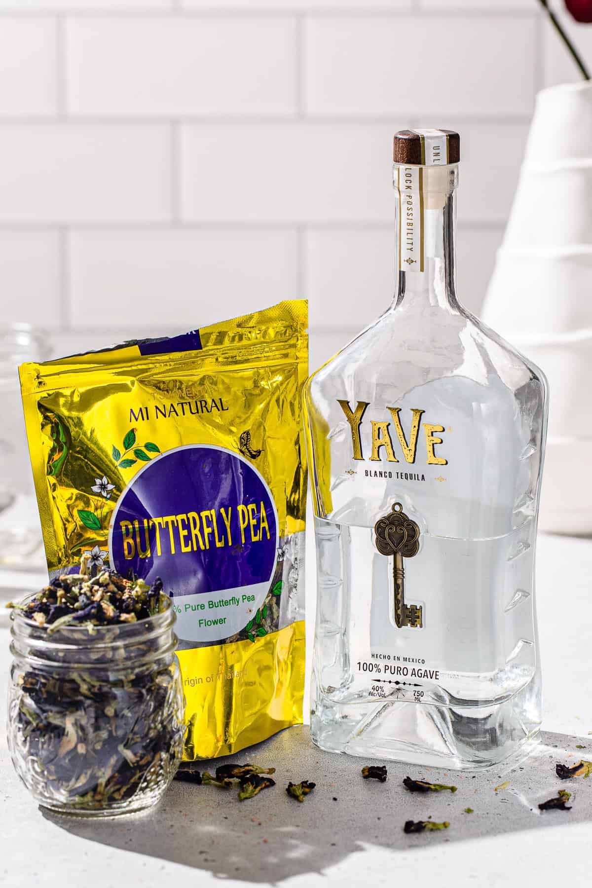 Ingredients to make a Butterfly Pea tequila infusion together on a countertop.