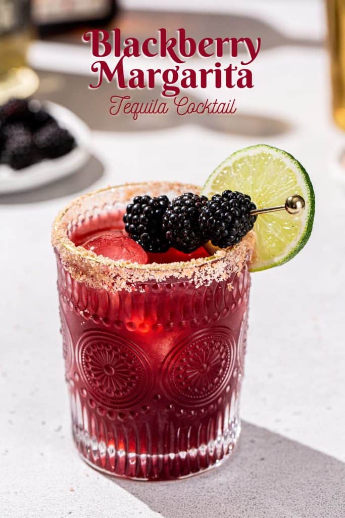 Blackberry Margarita cocktail on a countertop garnished with fresh blackberries and a lime slice. Text overlay above the drink says “Blackberry Margarita tequila cocktail”.