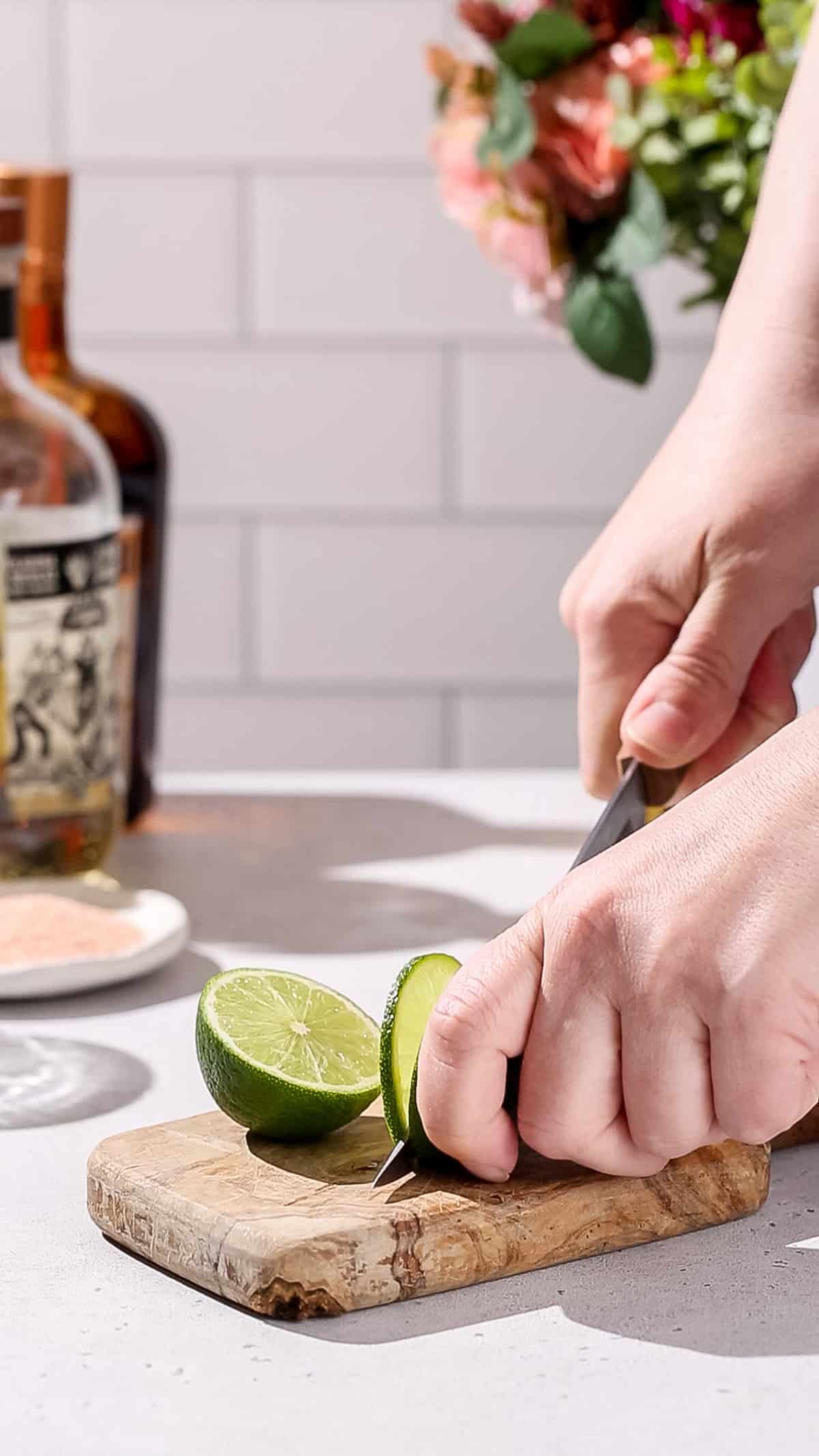 Hand cutting a slice of a fresh lime.