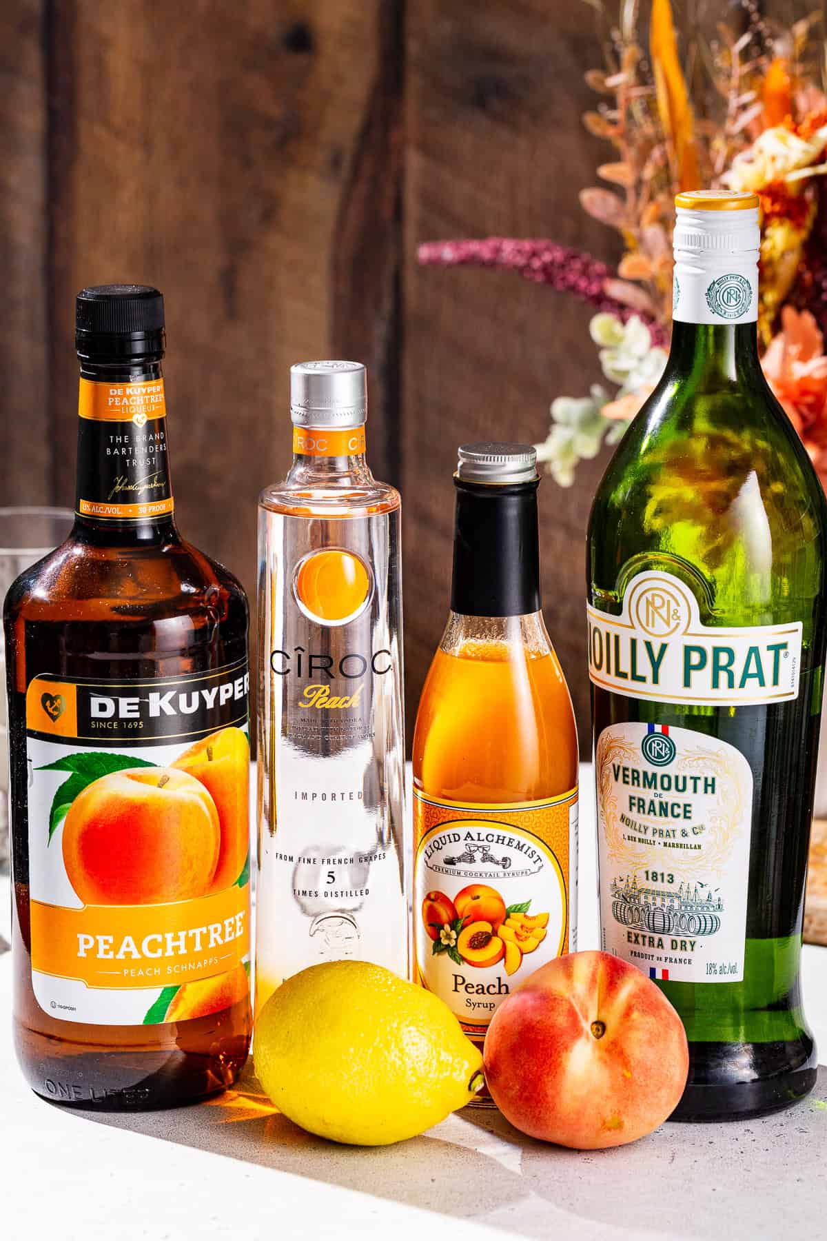 Ingredients to make a Peach Martini together on a countertop.