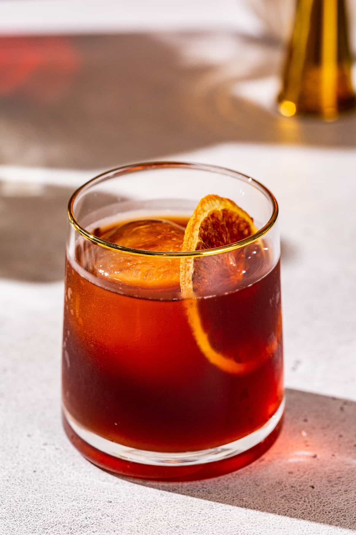 Coffee Negroni cocktail, garnished with a dried orange slice, in an old fashioned cocktail glass.