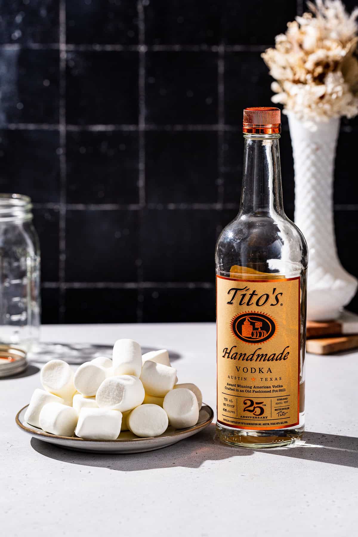 Ingredients to make Marshamllow Vodka together on a countertop.