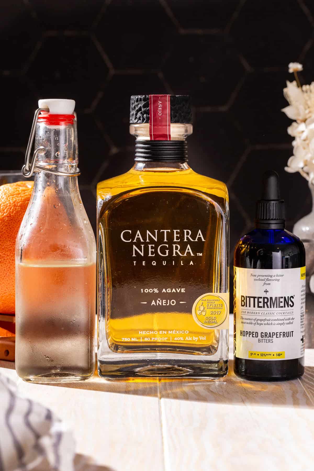 Ingredients to make a Smoked Añejo Old Fashioned together on a countertop.