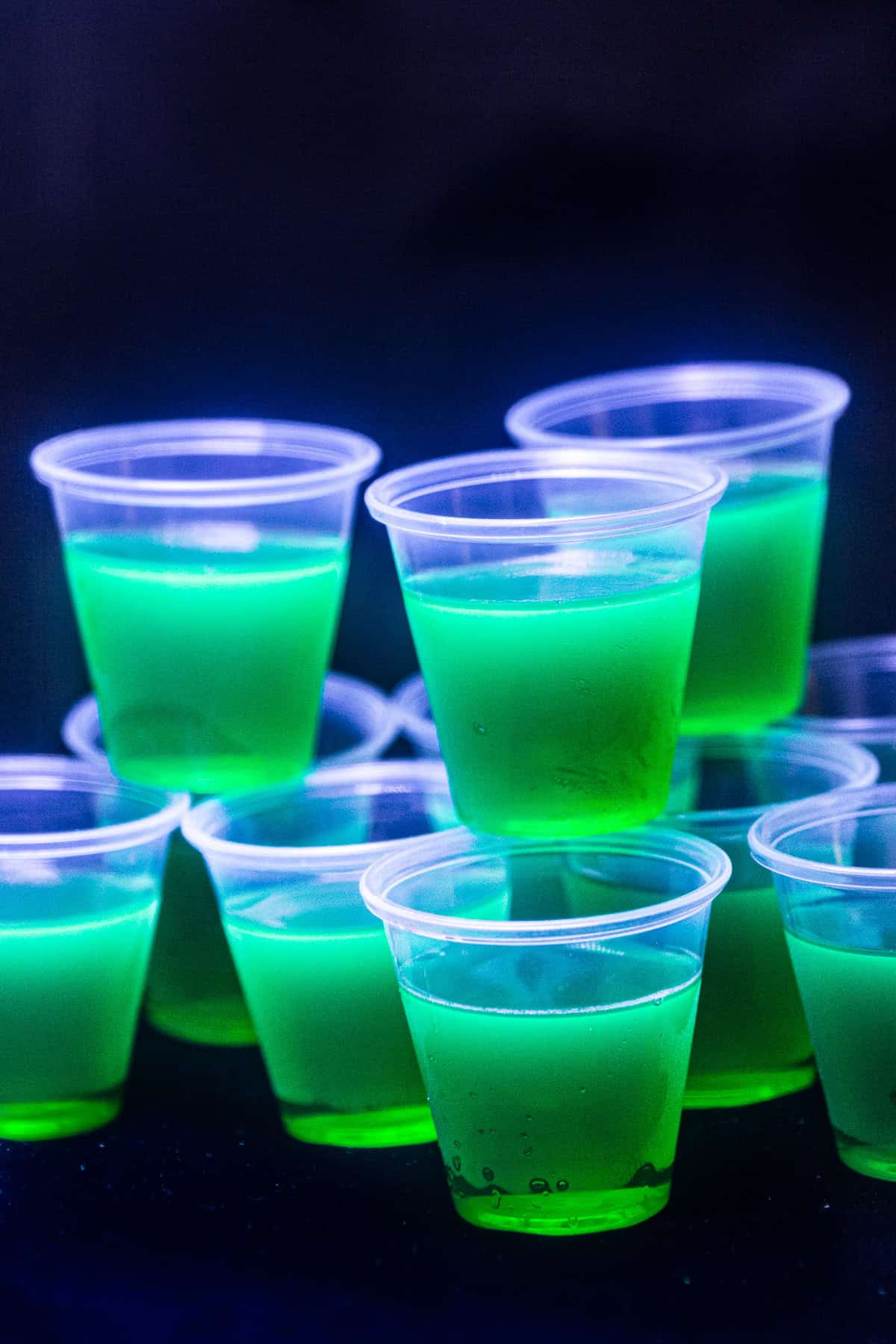 Lime green glow in the dark jello shots under blacklight.