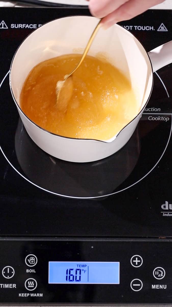 Hand stirring the slushy gelatin mixture as it starts to heat up.