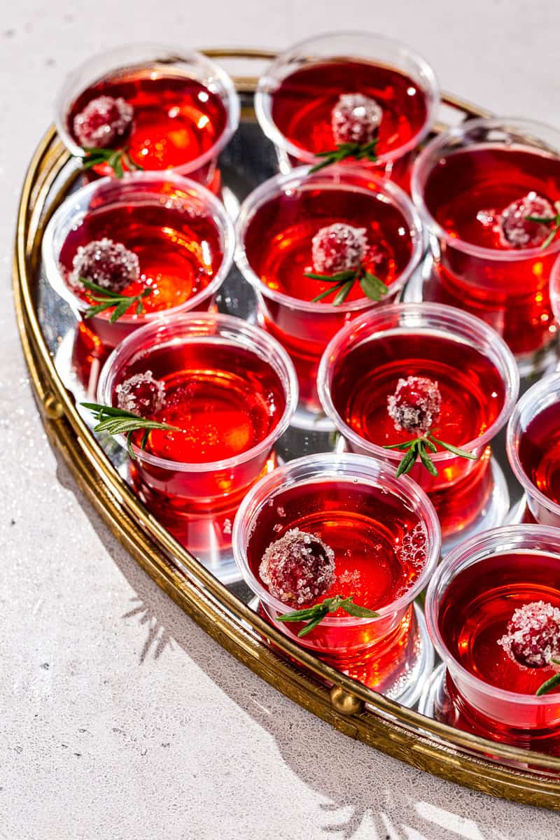 Overhead view of Cranberry Christmas Jello Shots on a mirrored tray.