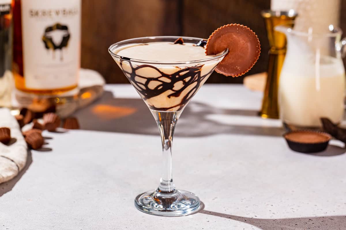 Peanut Butter Cup Martini cocktail on a countertop with a whole peanut butter cup as garnish.