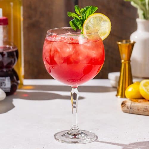 Side view of a Pomegranate Spritzer Mocktail in a spritz style glass.