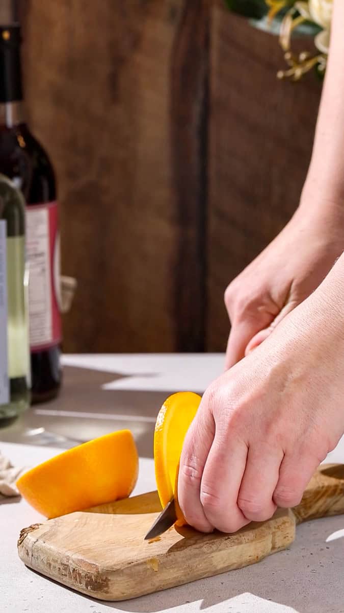 Hand cutting a slice of orange.