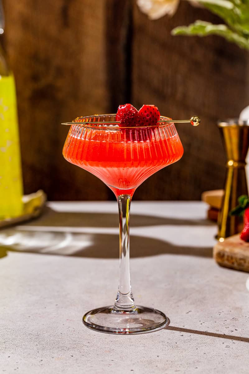 Side view of a Strawberry Lemon Martini in a coupe glass with a strawberry garnish.
